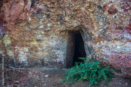 Fototapeta Naklejka Na Ścianę i Meble -  Abandoned gold mine adit in Troodos mountains near Analiontas, Cyprus. The colorful rocks are usual for this area rich of copper ore and sulfides