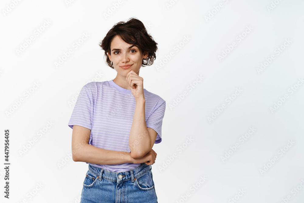 Portrait of confident smiling woman, smiling smug face and looking determined thoughtful, creative girl has a plan, standing against white background Portrait of confident smiling woman, smiling smug face and looking determined thoughtful, creative girl has a plan, standing against white background