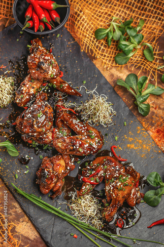 Baked chicken wings and legs with sesame seeds in honey mustard sauce with Indian spices. The concept of Indian cuisine.