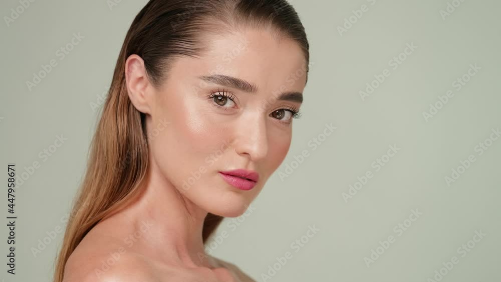 Beautiful Young Woman with Clean Fresh Skin standing over light grey background Beautiful Young Woman with Clean Fresh Skin standing over light grey background