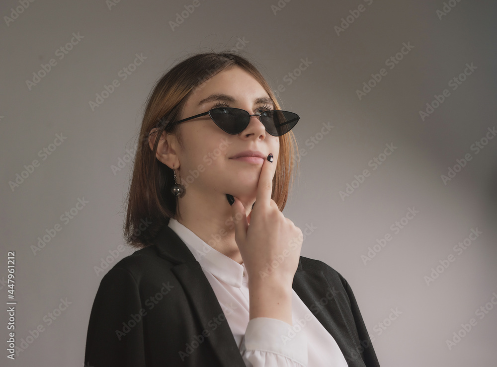 girl in white blouse, black jacket and sunglasses posing girl in white blouse, black jacket and sunglasses posing