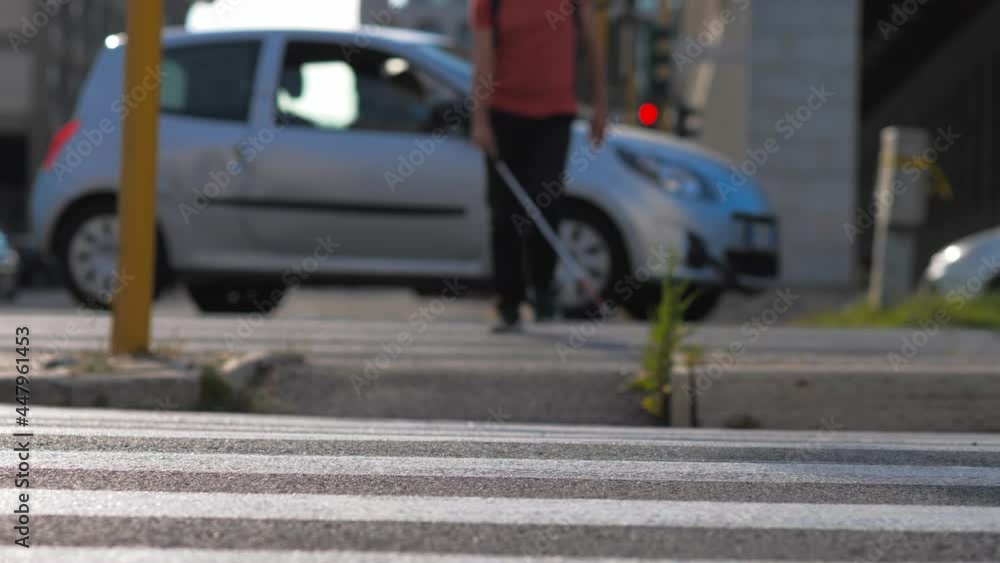 independent blind man wearing the mask crosses the street with his cane -blurred independent blind man wearing the mask crosses the street with his cane -blurred