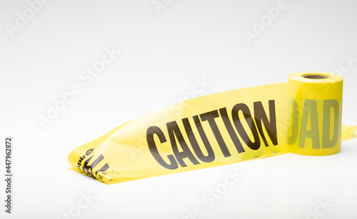 Roll of yellow plastic Caution warning tape used at contruction or emergency locations for safety warning notification on white background