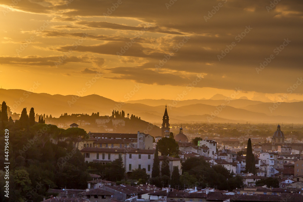 The hills surrounding the beautiful city of Florence, Italy at sunset, with the trees and church towers silhouetted