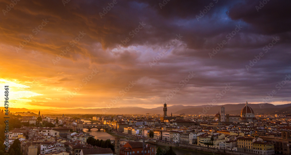 Fototapeta premium The cityscape of beautiful Florence, Italy, as the cloudy sky erupts with color as the sun sets
