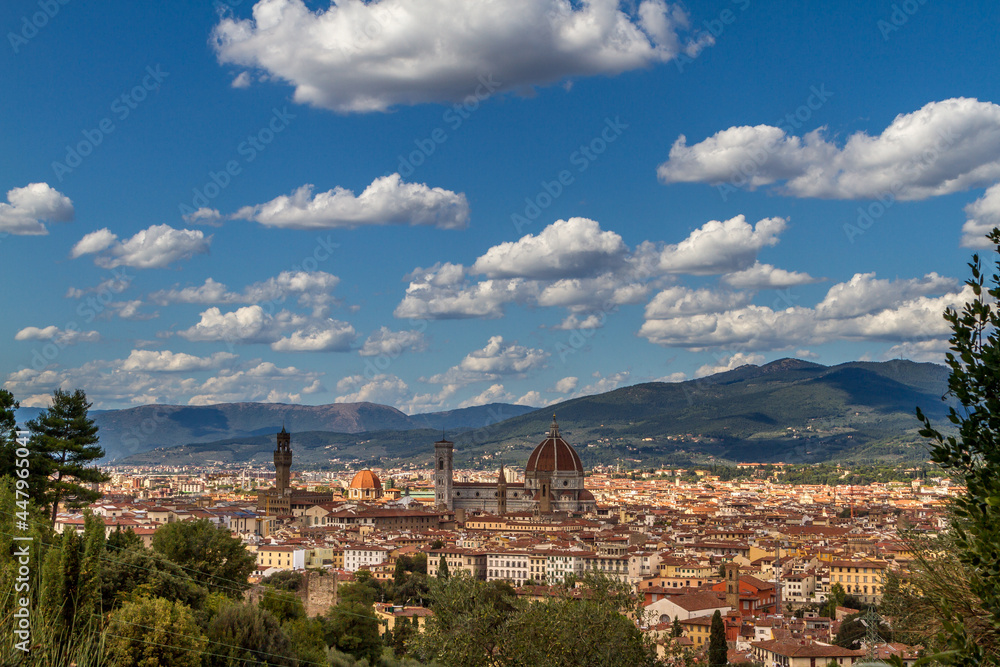 The cityscape of beautiful Florence, Italy, with fluffy clouds in the blue sky
