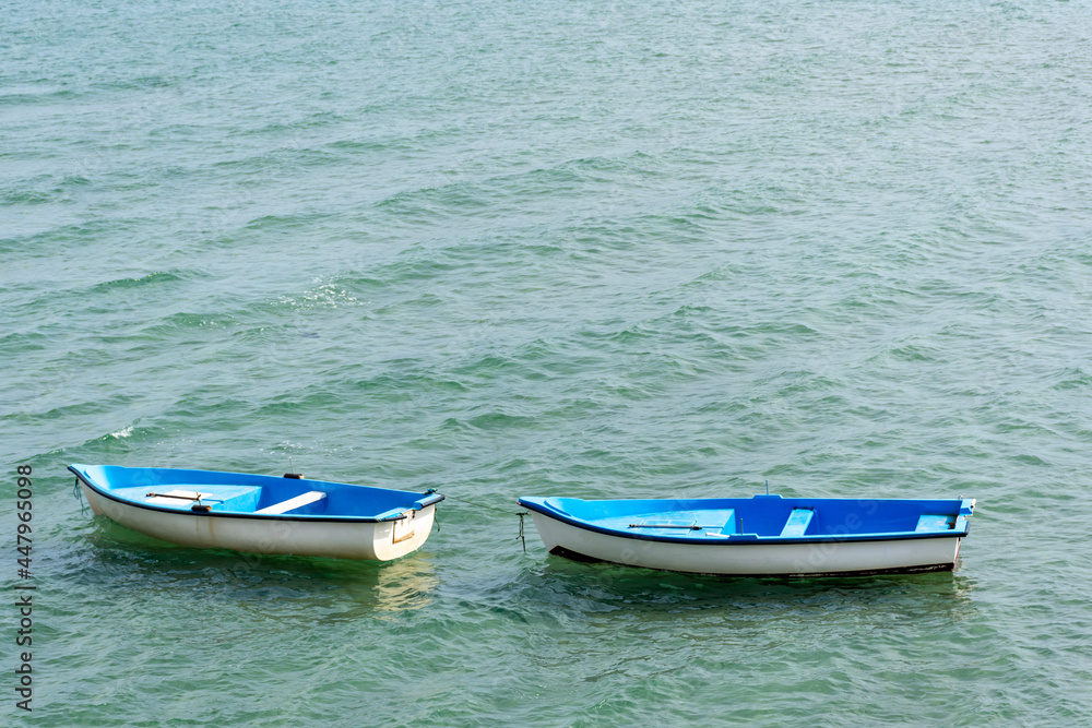 Aerial view of two empty fishing boats floating on water. Aerial view of two empty fishing boats floating on water.