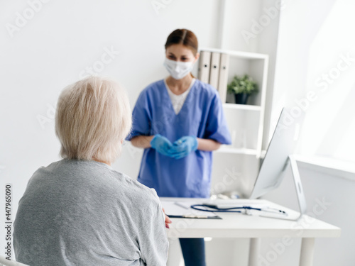 female doctor communicating with elderly patient in hospital safety infection covid passport