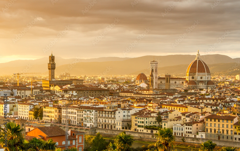 The cityscape of beautiful Florence, Italy, as the cloudy sky erupts with color as the sun sets