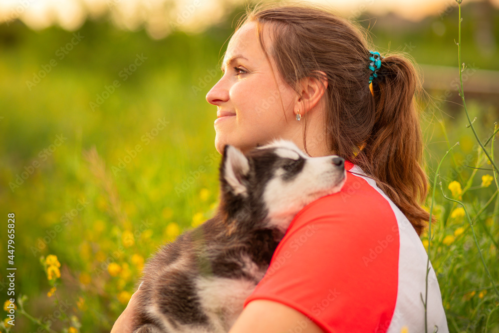 Beautiful young caucasian woman is playing with her puppy dog outdoor. Animal, friendship, people and love concept