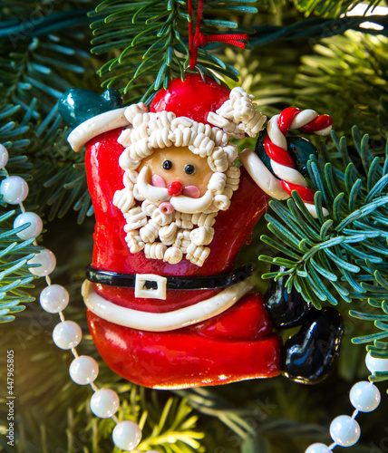 A styalized Santa Christmas tree ornament hanging on a fir tree photo
