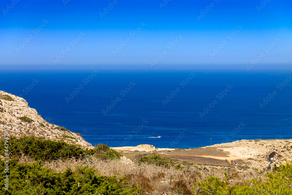 A view of the Mediterranean Sea of Cyprus from the viewpoint of Capo Greco National Park. A tourist motor boat is visible in the distance.