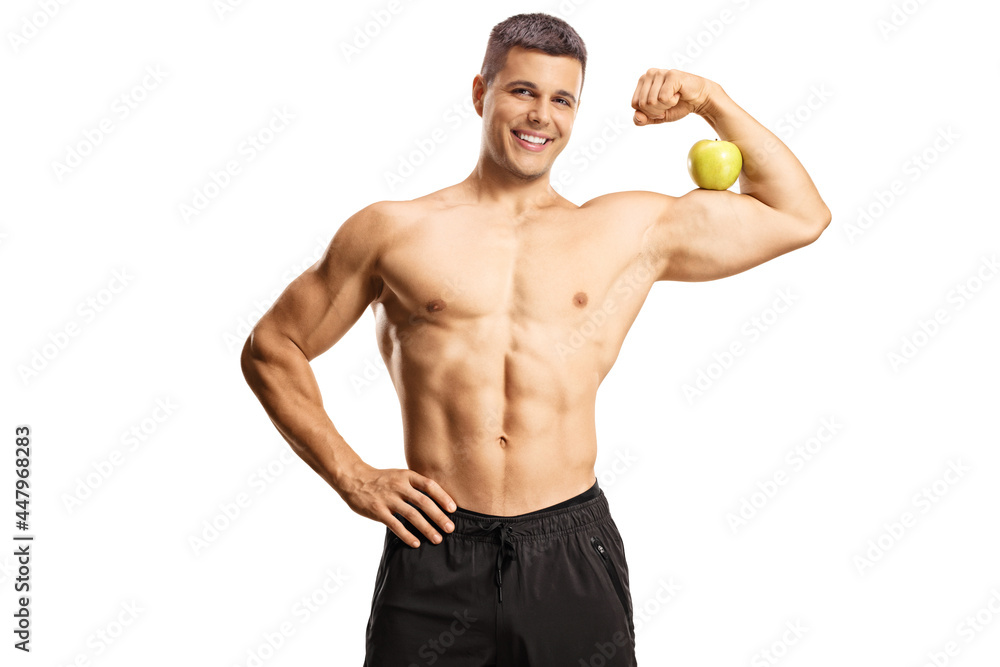 Fototapeta premium Young shirtless musuclar man flexing arm muscle and holding an apple