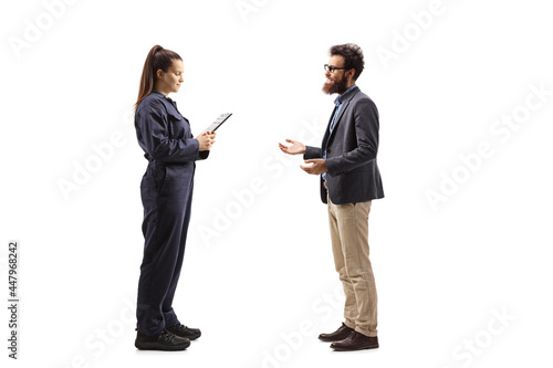 Full length profile shot of female auto mechanic having a conversation with a customer