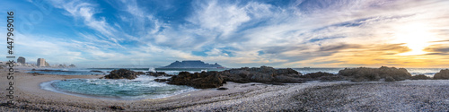 Scenic sunset beach vista of Table Mountain, Cape Town, South Africa. A stunning view from Table View beach - across the bay where tourists and surfers alike come to enjoy the beach and ocean.	
