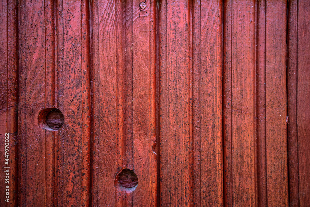 The texture of a wooden clapboard painted with red rowan color paint