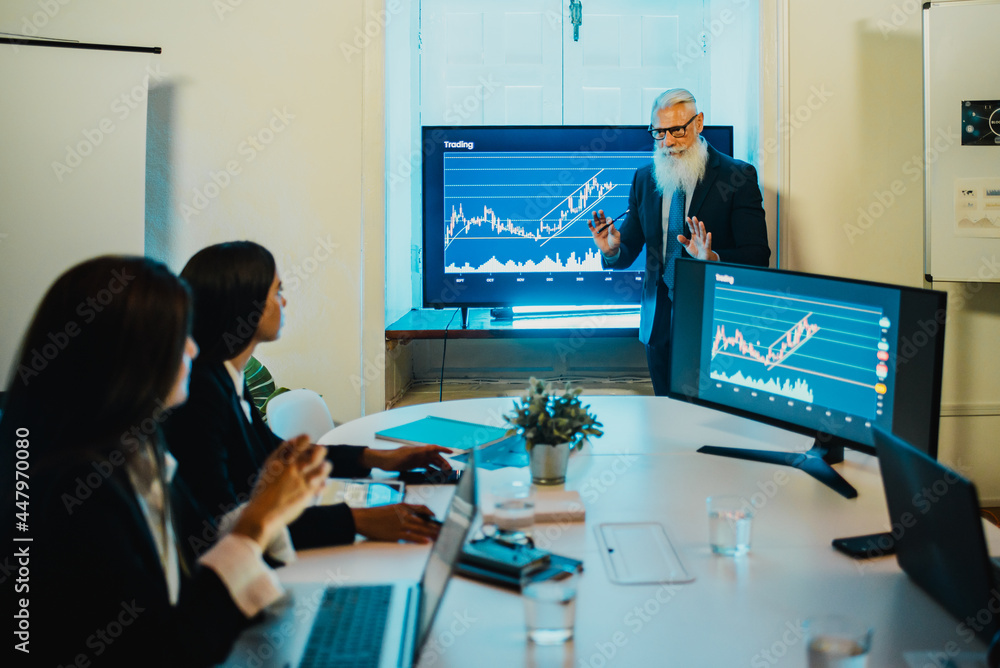 Trader senior man doing stock coin market presentation to team inside bank office - Focus on male face Trader senior man doing stock coin market presentation to team inside bank office - Focus on male face