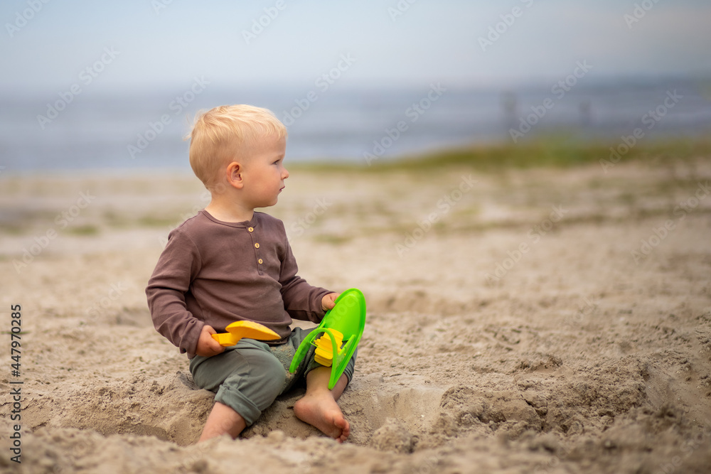 cute baby playing in the sand with sand toys on the beach. cute baby playing in the sand with sand toys on the beach.