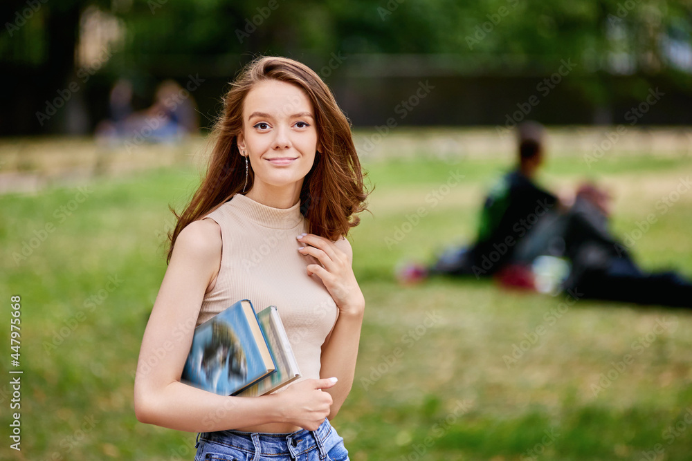 Happy graceful woman with books in hands outside. Happy graceful woman with books in hands outside.