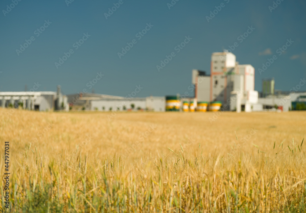Blurred factories in wheat fields background Blurred factories in wheat fields background