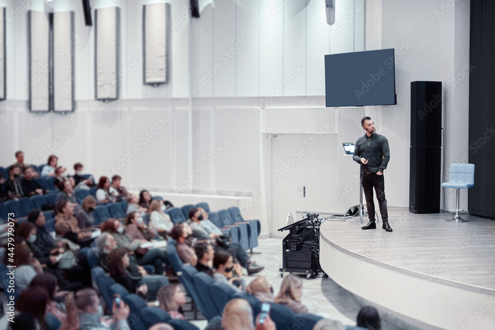 speaker standing on the stage in the conference hall.