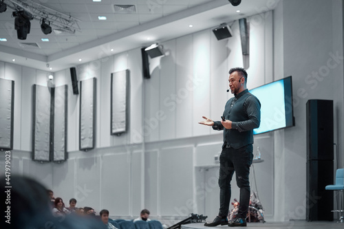 speaker giving a lecture on stage in the conference hall.