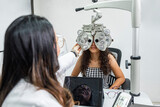 Una mujer medico de la salud visual realizando un examen de la vista a una paciente con maquinas especiales