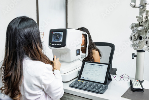 Quadro em tela Una mujer medico de la salud visual realizando un examen de la vista a una pacie