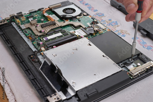 Laptop repair. Mount SSD disk. Hand screwdriver photo
