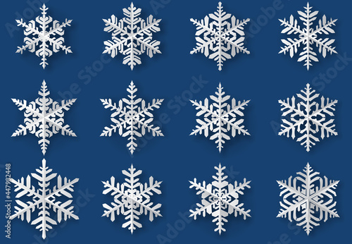 Set of beautiful complex paper Christmas snowflakes with soft shadows, white on blue background