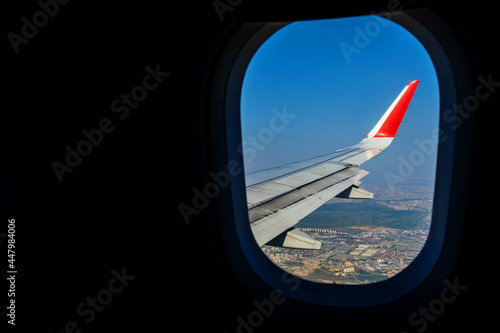 Looking through window aircraft during flight in wing lands over Istanbul in sunny weather