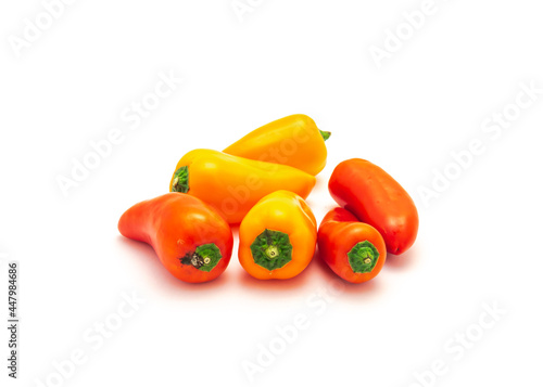 Pile of colorful orange and red mini sweet peppers snack isolate on white