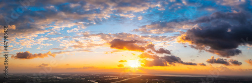 Aerial view of beautiful clouds and sun at sunset.