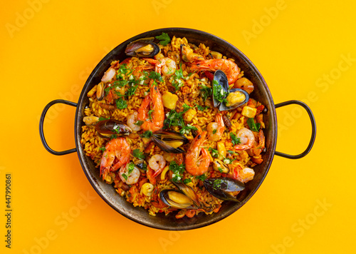 Traditional spanish seafood paella with rice, mussels, shrimps in a pan on white background. view from above, flat lay