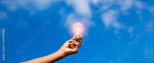 Hand holding light bulb,natural energy and love the world concept.
