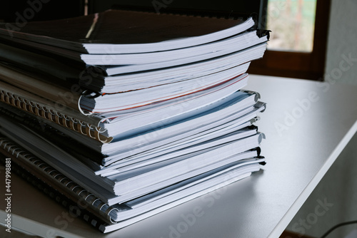Stack of reports lies on a desk ready for review