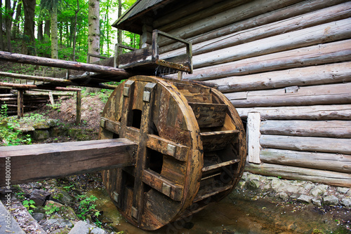 An old water mill. Blurred forest background.