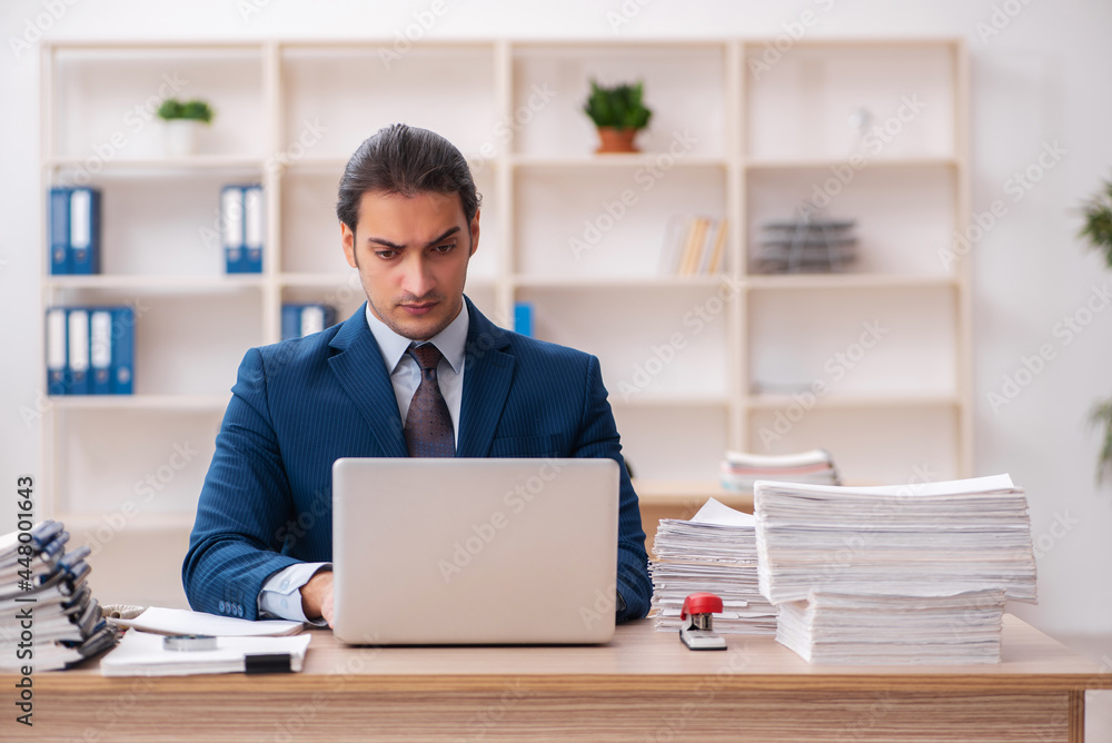 Young male employee unhappy with excessive work Young male employee unhappy with excessive work