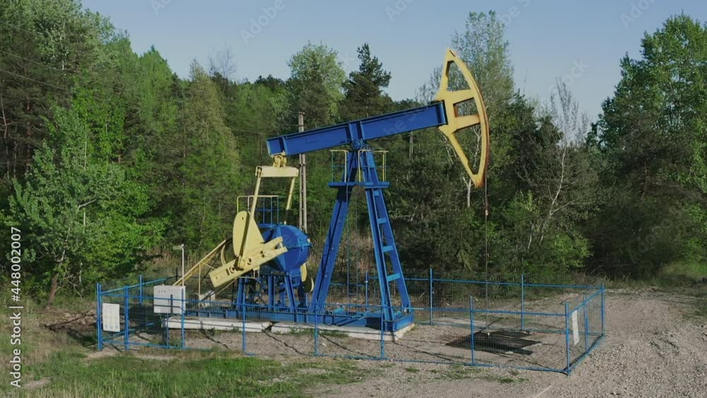 Industrial Oil Pumpjack At Work Pumping Crude Oil With Drilling Rig In Oilfield Near Campina In Romania. static shot Industrial Oil Pumpjack At Work Pumping Crude Oil With Drilling Rig In Oilfield Near Campina In Romania. static shot