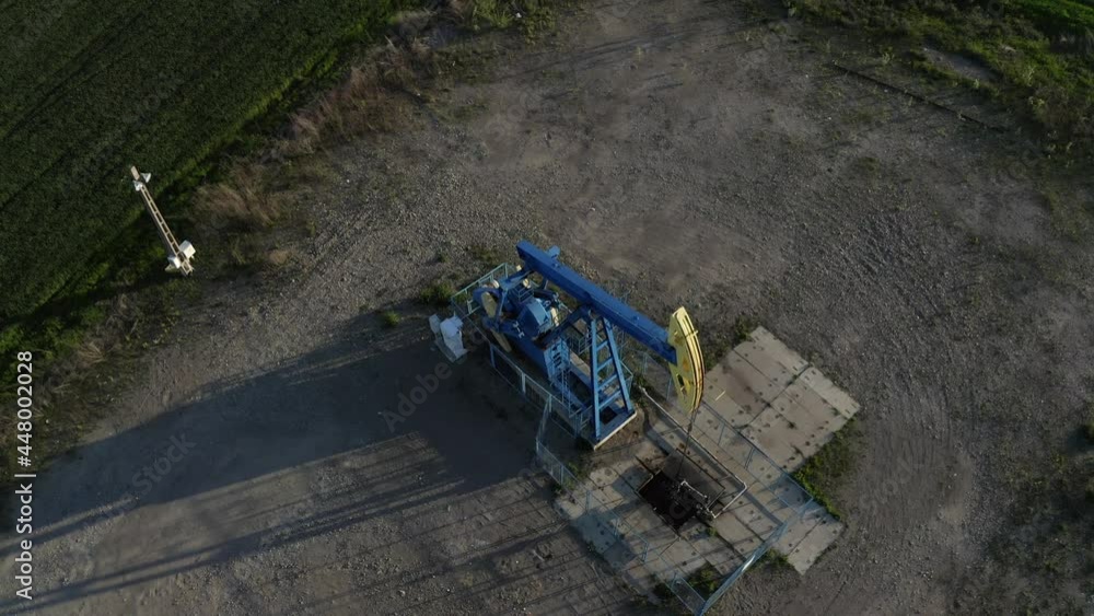 Aerial View Of An Oil Pumpjack Operating In The Oilfield Near Ploiesti, Romania At Daytime. drone descend Aerial View Of An Oil Pumpjack Operating In The Oilfield Near Ploiesti, Romania At Daytime. drone descend