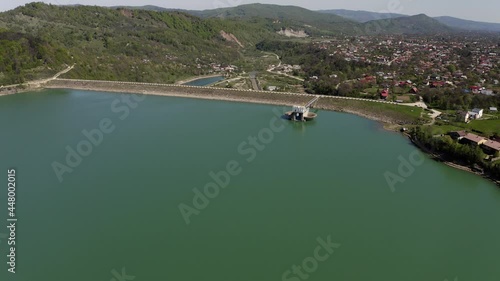 Aerial View Of Calm Waters Of Maneciu Dam In Prahova County, Romania. dolly-in drone, tilt down photo
