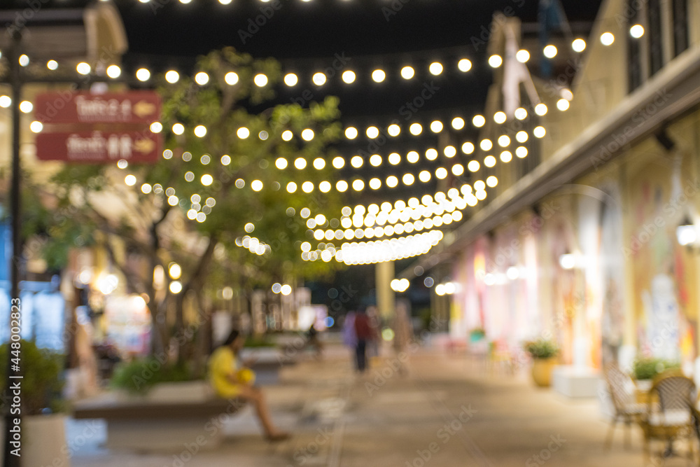 abstract blur image of night festival with a street walk and led light on tree bokeh for background