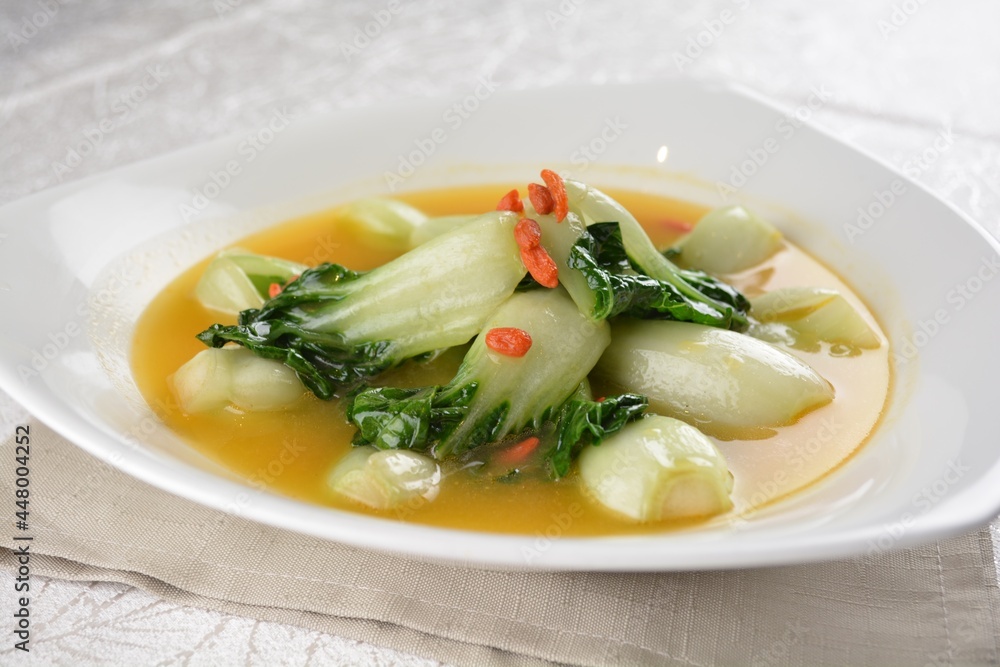 stir fried small cabbage with Chinese herbal in yellow chicken stock soup in white background asian halal vegan menu stir fried small cabbage with Chinese herbal in yellow chicken stock soup in white background asian halal vegan menu