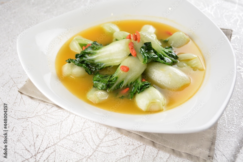 stir fried small cabbage with Chinese herbal in yellow chicken stock soup in white background asian halal vegan menu stir fried small cabbage with Chinese herbal in yellow chicken stock soup in white background asian halal vegan menu