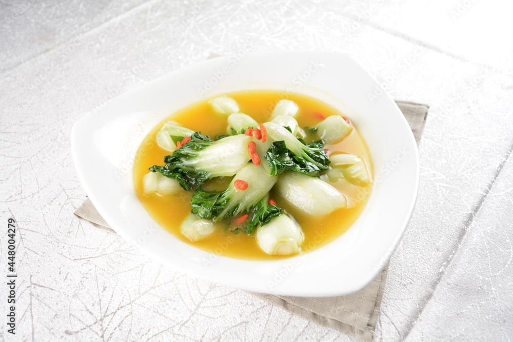 stir fried small cabbage with Chinese herbal in yellow chicken stock soup in white background asian halal vegan menu stir fried small cabbage with Chinese herbal in yellow chicken stock soup in white background asian halal vegan menu
