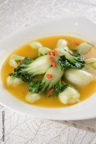 stir fried small cabbage with Chinese herbal in yellow chicken stock soup in white background asian halal vegan menu