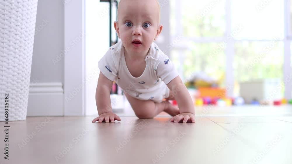 happy smiling blue eyes baby infant lying on the floor and tries to sit down or to crawl happy smiling blue eyes baby infant lying on the floor and tries to sit down or to crawl