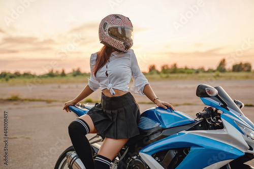 Obraz na płótnie Female motorcyclist and modern motorbike on country road