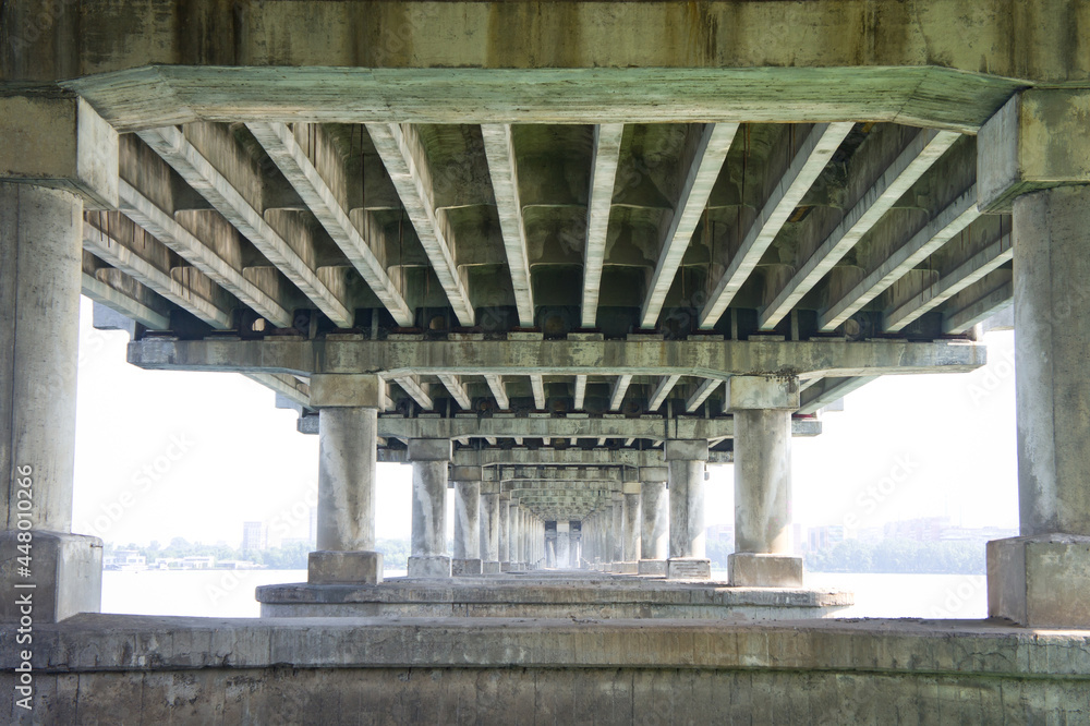 Reinforced concrete supports of a wide road bridge, taken from the lower angle. Reinforced concrete supports of a wide road bridge, taken from the lower angle.