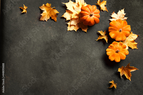 Autumn background with pumpkins and maple leaves